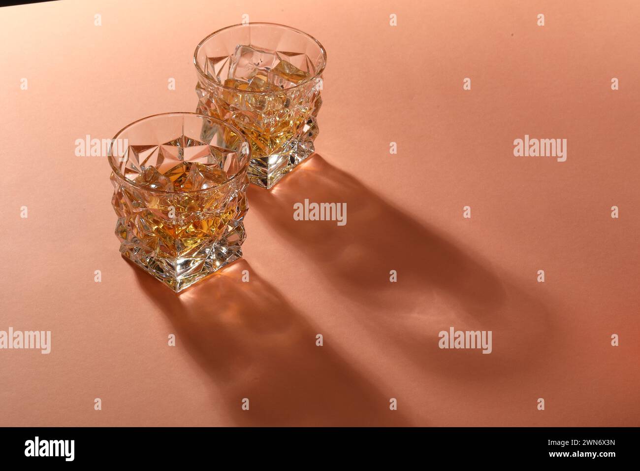 Whiskey mit Eiswürfeln in Gläsern auf Korallentisch, Platz für Text Stockfoto