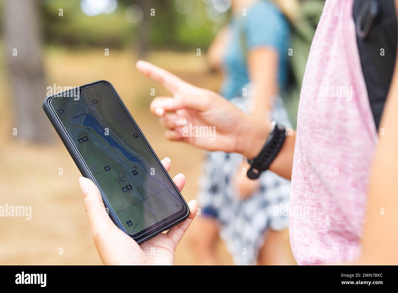 Zwei Personen verwenden ein Smartphone, um während der Wanderung zu navigieren. Stockfoto