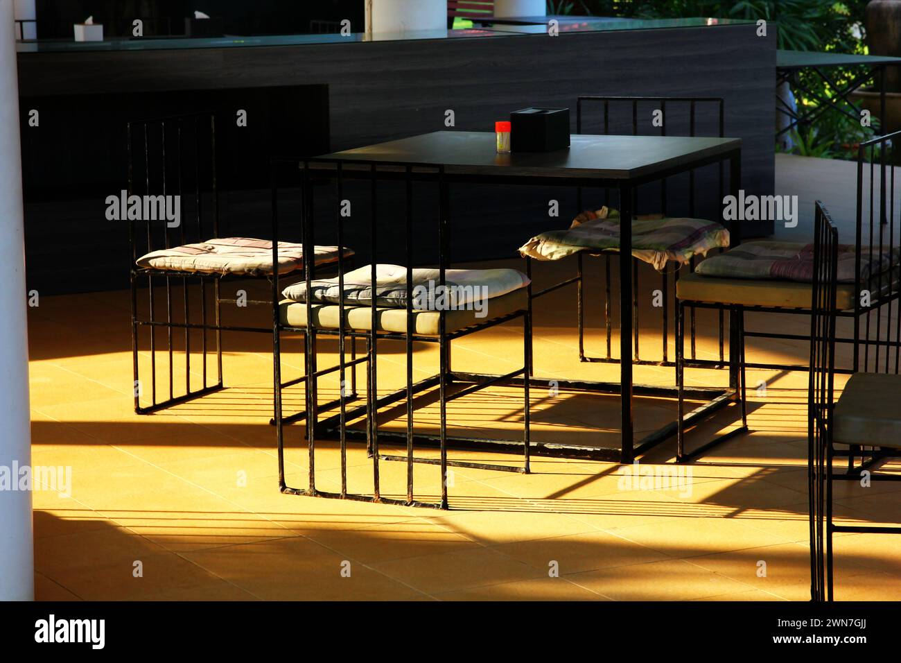 Set aus schwarzem Stahlstuhl mit Morgenlicht und Schatten Stockfoto