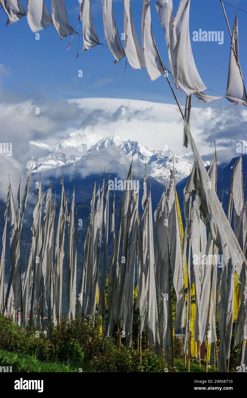 Malerischer vertikaler Blick auf die schneebedeckte Kangchenjunga-Bergkette durch buddhistische Gebetsfahnen und Banner in Pelling, Sikkim, Indien Stockfoto