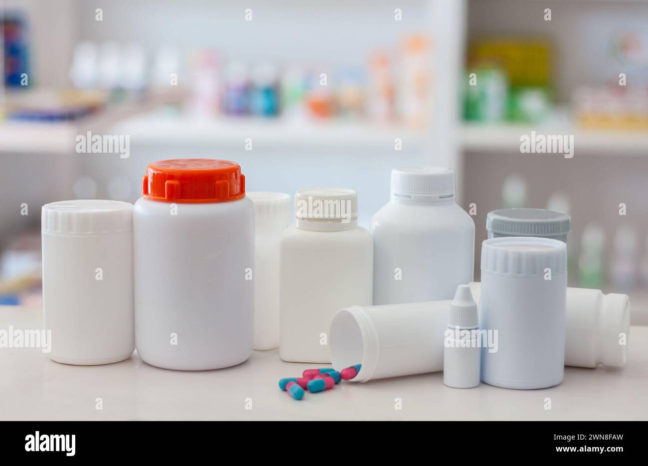 Zusammensetzung von Arzneimittelflaschen und Pillen mit Apothekenregalen im Hintergrund Stockfoto