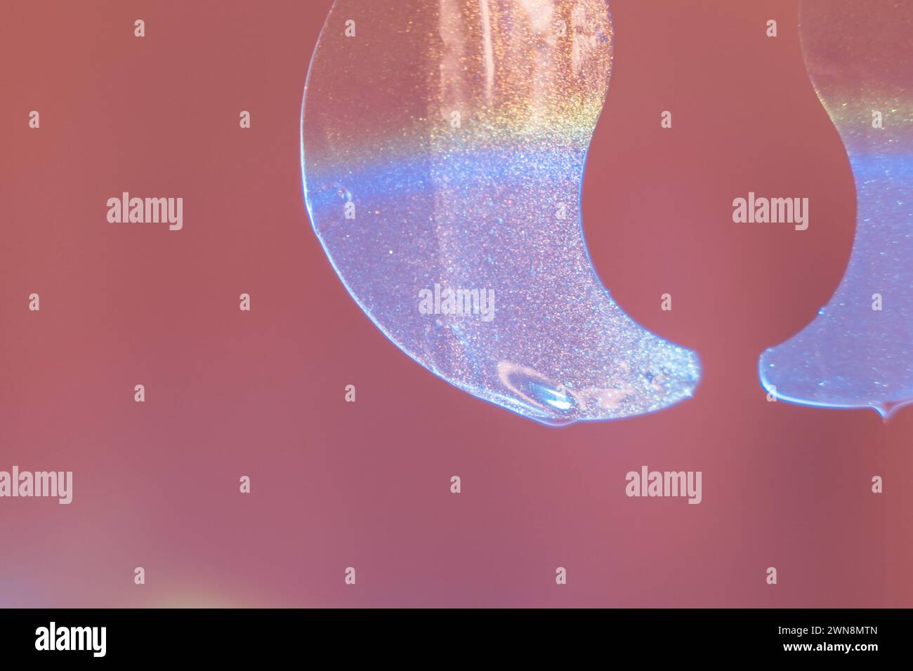 Transparente Augenflecken hängen vor rotem Hintergrund Stockfoto
