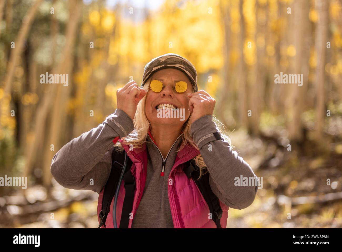 Eine Frau mit gelben Blättern, die ihre Augen zieren Stockfoto