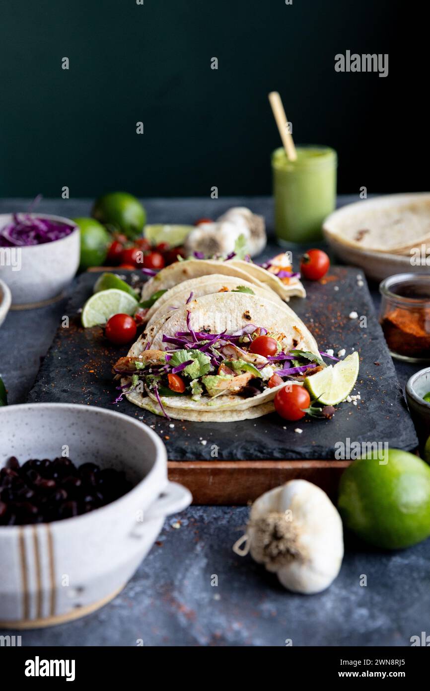 Blick auf Augenhöhe auf Tacos auf dunklem Hintergrund mit farbenfrohen Zutaten Stockfoto