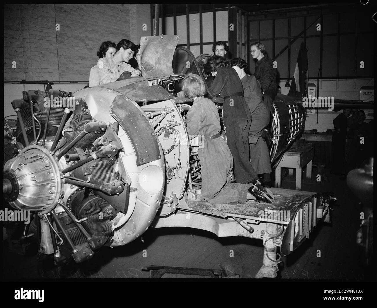 Vintage-Fotografien von Frauen, die im Zweiten Weltkrieg in Werkstätten ausgebildet wurden, als Teil des wichtigen Beitrags der Frauen zu den Kriegsbemühungen. W.A.A.F.s arbeiten an einem Flugzeugrumpf am Ultimo Technical College, Sydney, Australien 1943 Stockfoto
