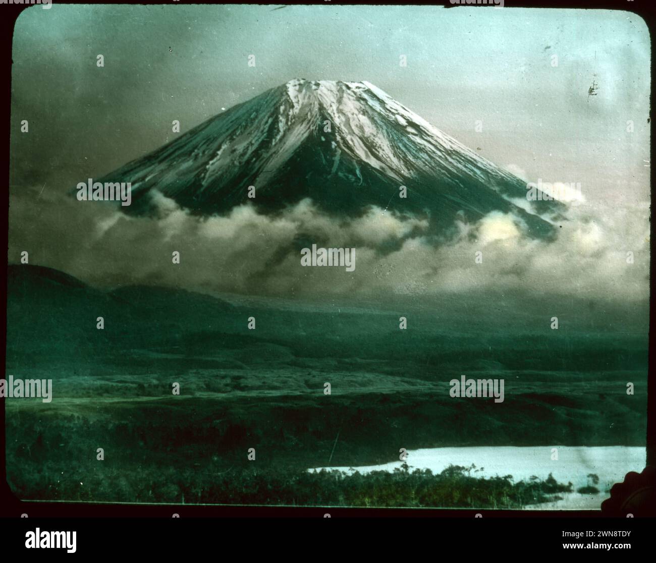Schneebedeckter Fuji-Berg, der über den Wolken ragt. Aus Hebert Geddes 'Life in Japan' Kollektion: Handfarbige Vintage-Glasfolien aus der Meiji-Ära. Yokohama, Japan Ende des 19. Jahrhunderts. Diese Bilder von verschiedenen japanischen Künstlern wurden an Besucher verkauft. Stockfoto