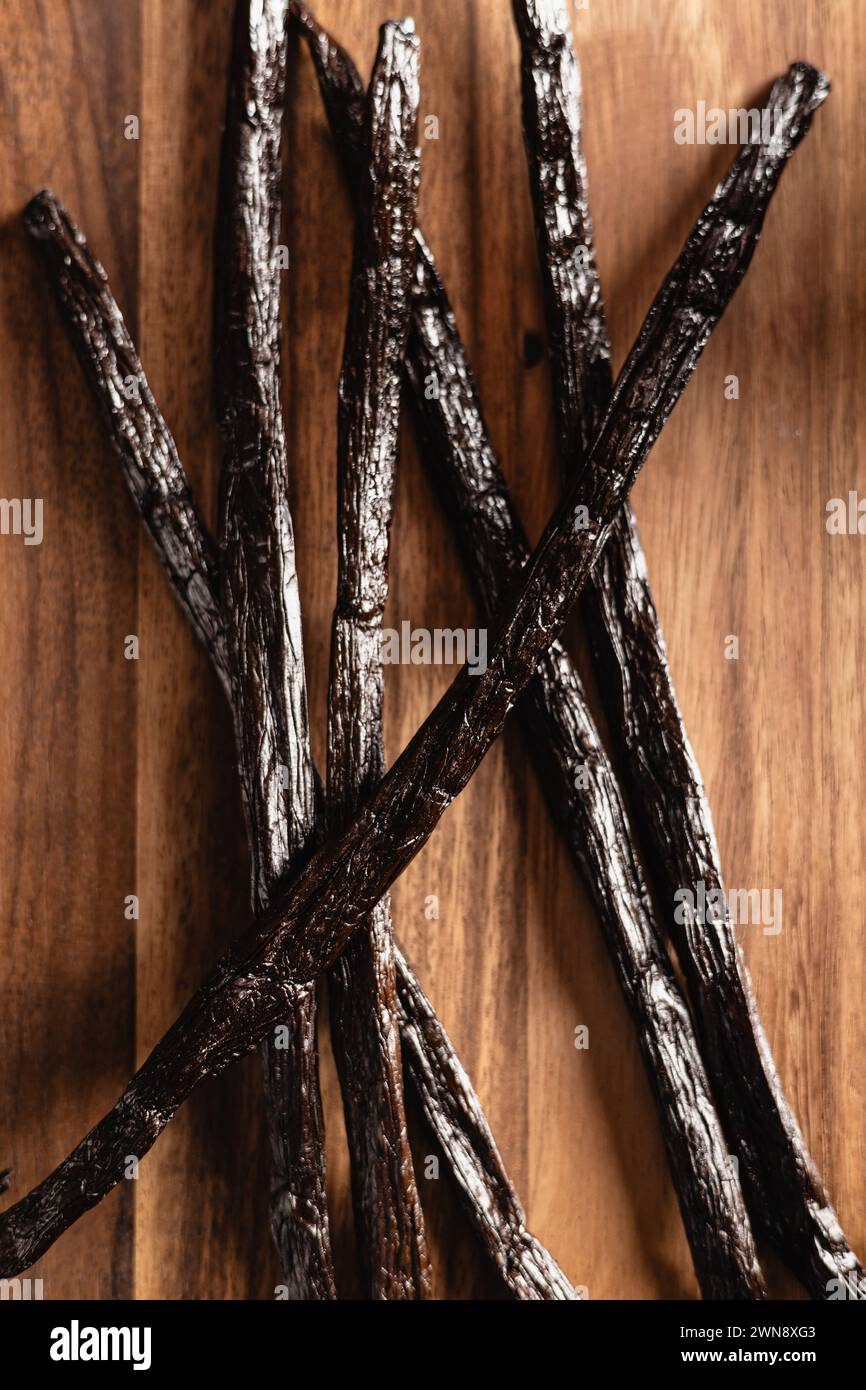 Vanillebohnen auf einem Holzbrett Stockfoto