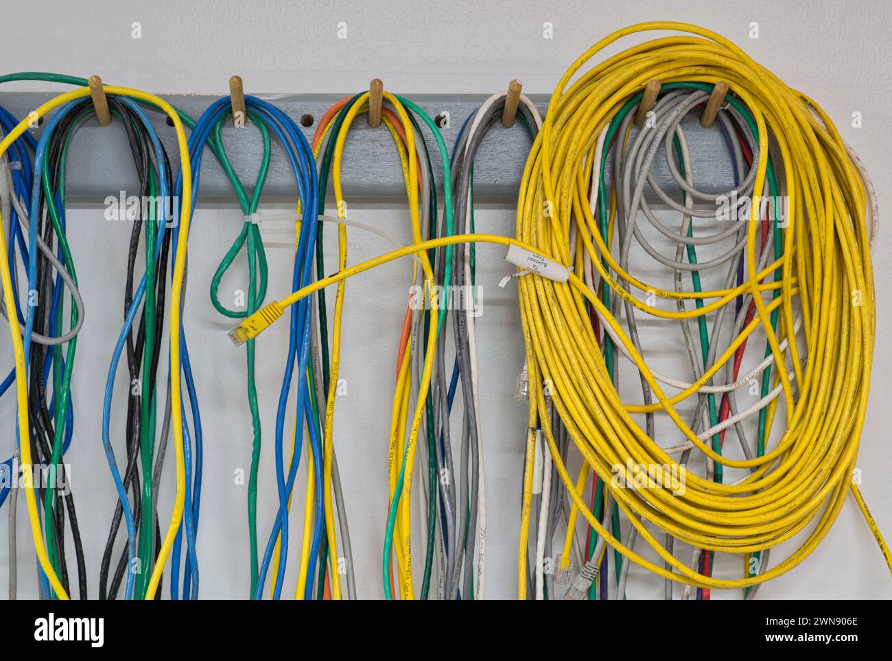 Houston, Texas USA 12-27-2023: Bunte alte elektrische Kabel hängen an einer Wand. CAT5 Twisted-Pair-Kabel für Computernetzwerke. Stockfoto