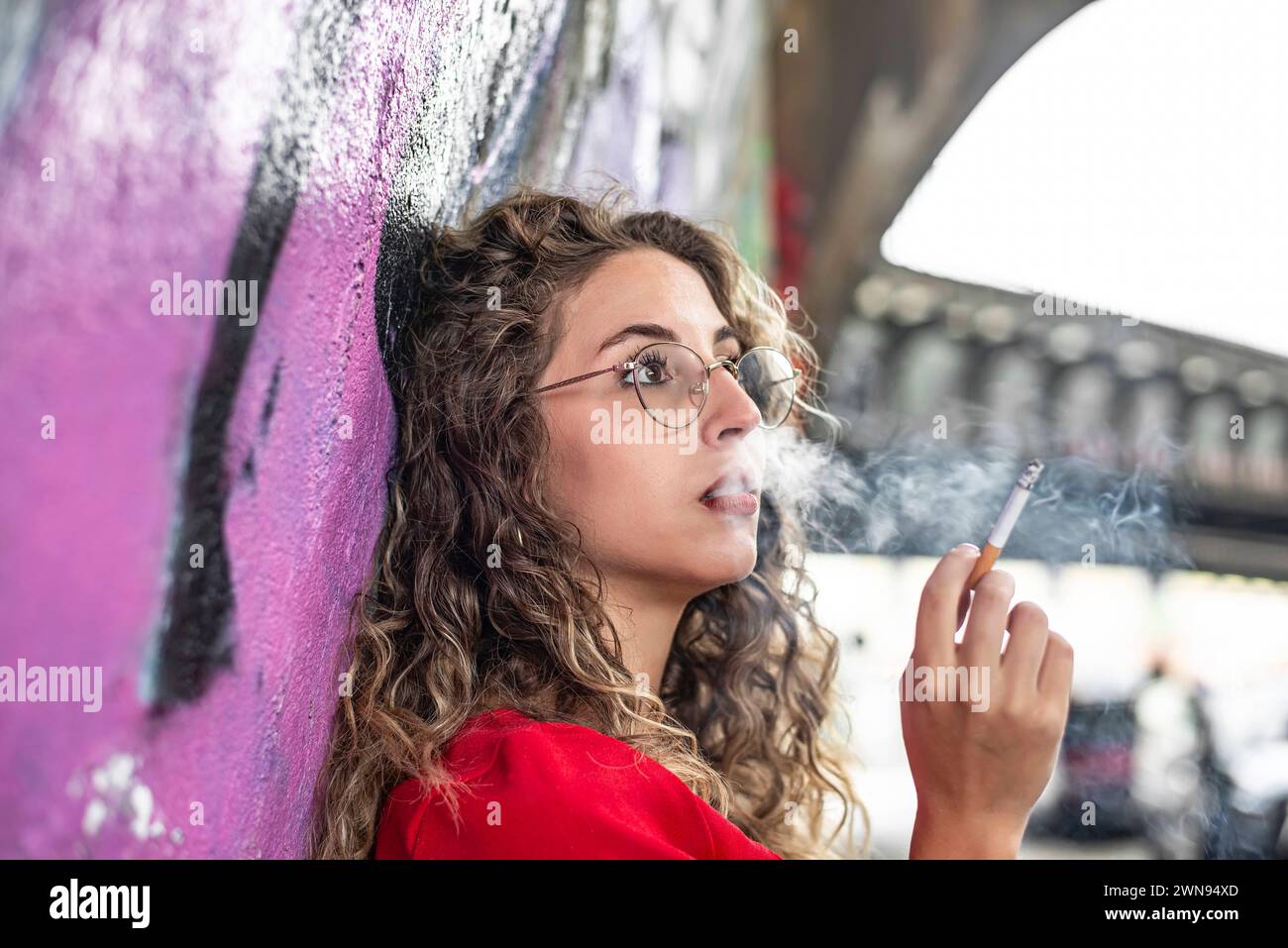 Nachdenkliche junge Frau raucht eine Zigarette *** Lokalunterschrift *** *** nachdenkliche junge Frau raucht eine Zigarette Lokalunterschrift Stockfoto