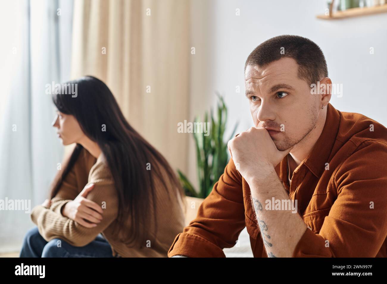 Frustriertes junges interrassisches Paar, das zu Hause im Schlafzimmer sitzt, Beziehungsschwierigkeiten Konzept Stockfoto