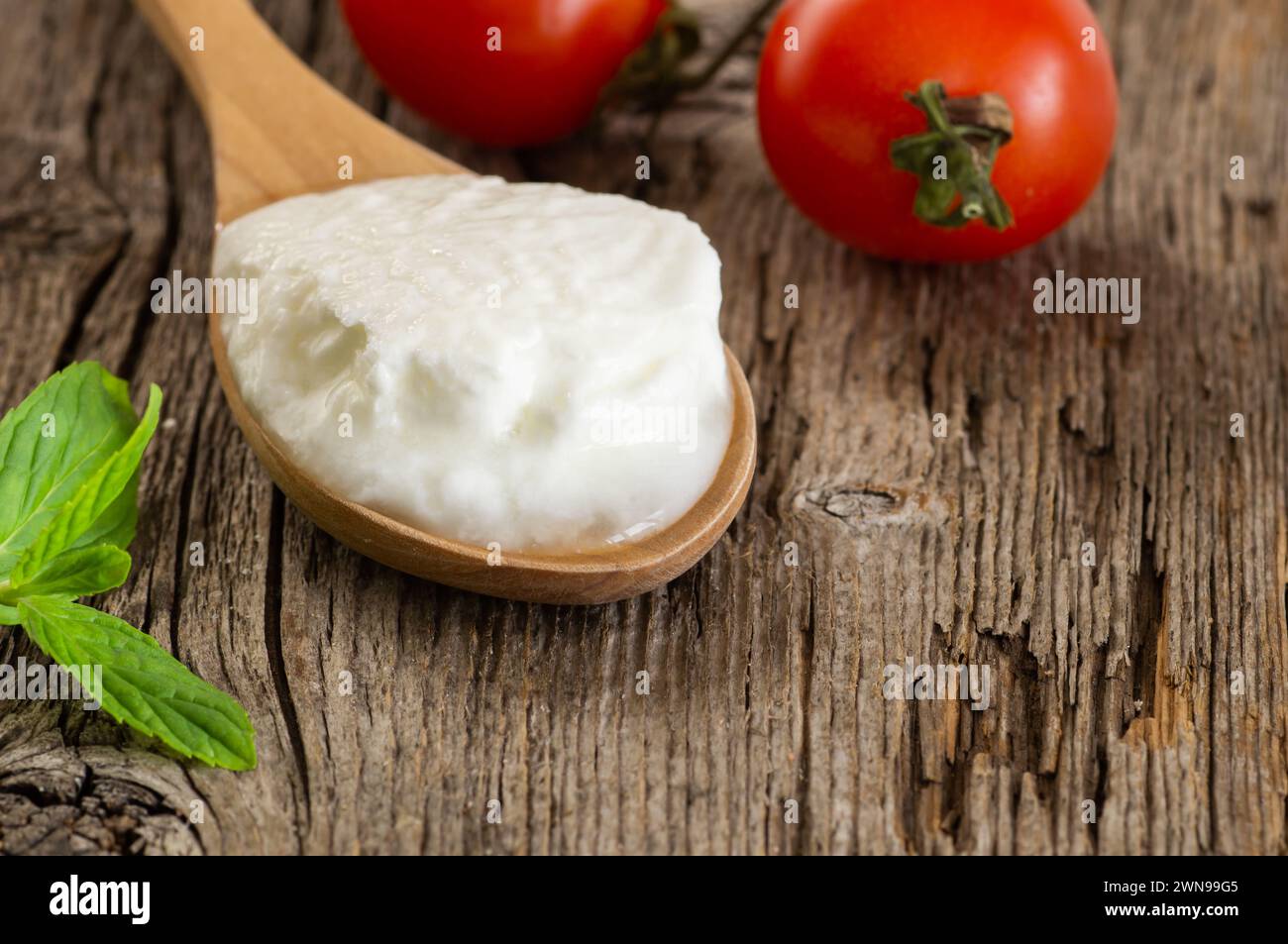 Hausgemachter Joghurt mit Creme in einem Holzlöffel, gesundes Essen Stockfoto