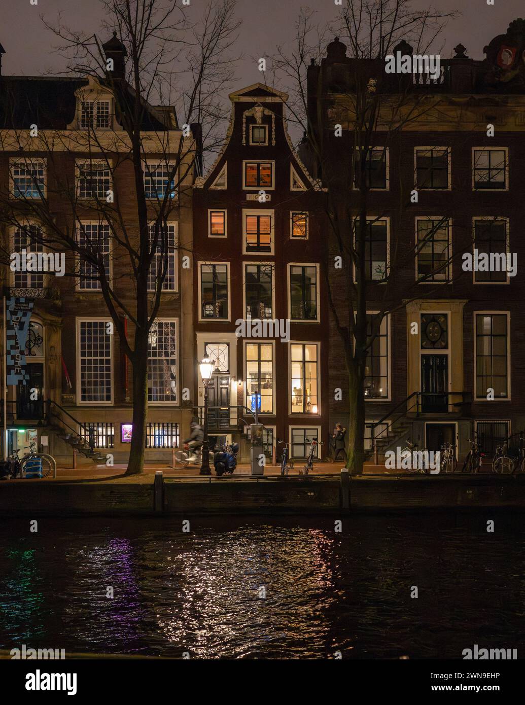 Die Häuser leuchten nachts auf dem Herengracht-Kanal, Amsterdam, Niederlande Stockfoto