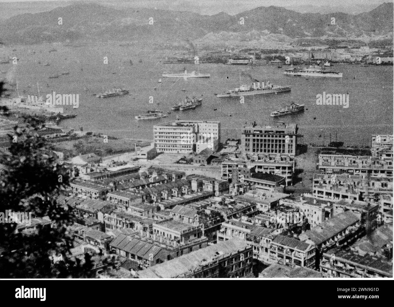 Schiffe der chinesischen Flotte der Royal Navy vor Anker im Hafen von Hongkong während der 1930er Jahre Das Vorhandensein des Flugzeugträgers HMS Eagle (oben rechts) datiert das Foto entweder auf 1934 oder 1937-39. Zwei schwere Kreuzer der County-Klasse mit drei Trichtern und mehrere Zerstörer wurden ebenfalls gesehen Stockfoto