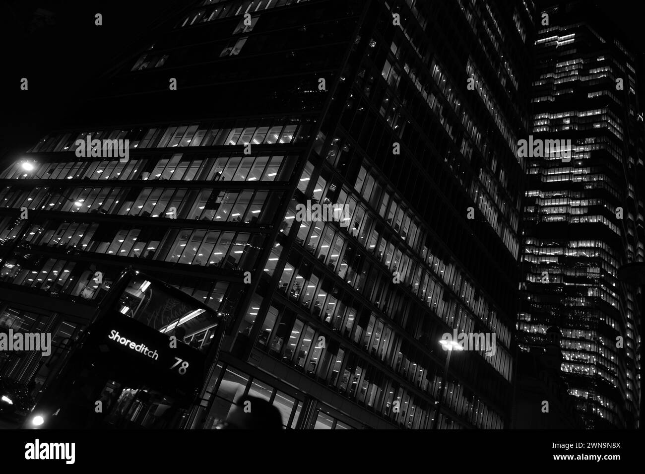 Eindrucksvolle abstrakte, monochrome Architekturlandschaft mit Wolkenkratzer-Büros, beleuchtet bei Nacht auf dem Bishopsgate in der Nähe der Liverpool Street in der City of London. Stockfoto