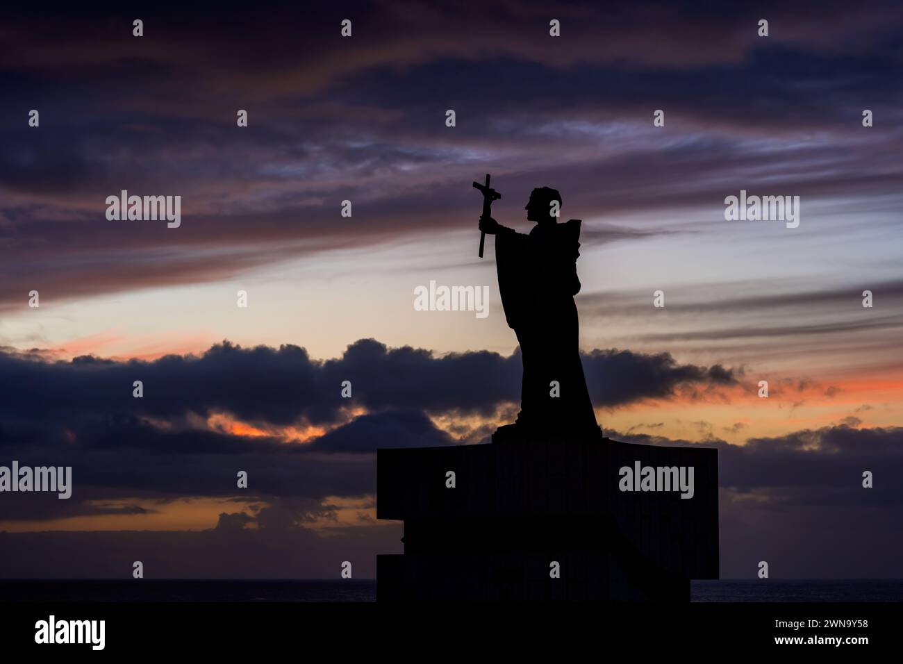 Statue von Sao Goncalo de Lagos (1360-1422) Silhouette vor dem Abendhimmel in Lagos, Algarve, Portugal. Denkmal für den schutzheiligen der Stadt mit einem Stockfoto