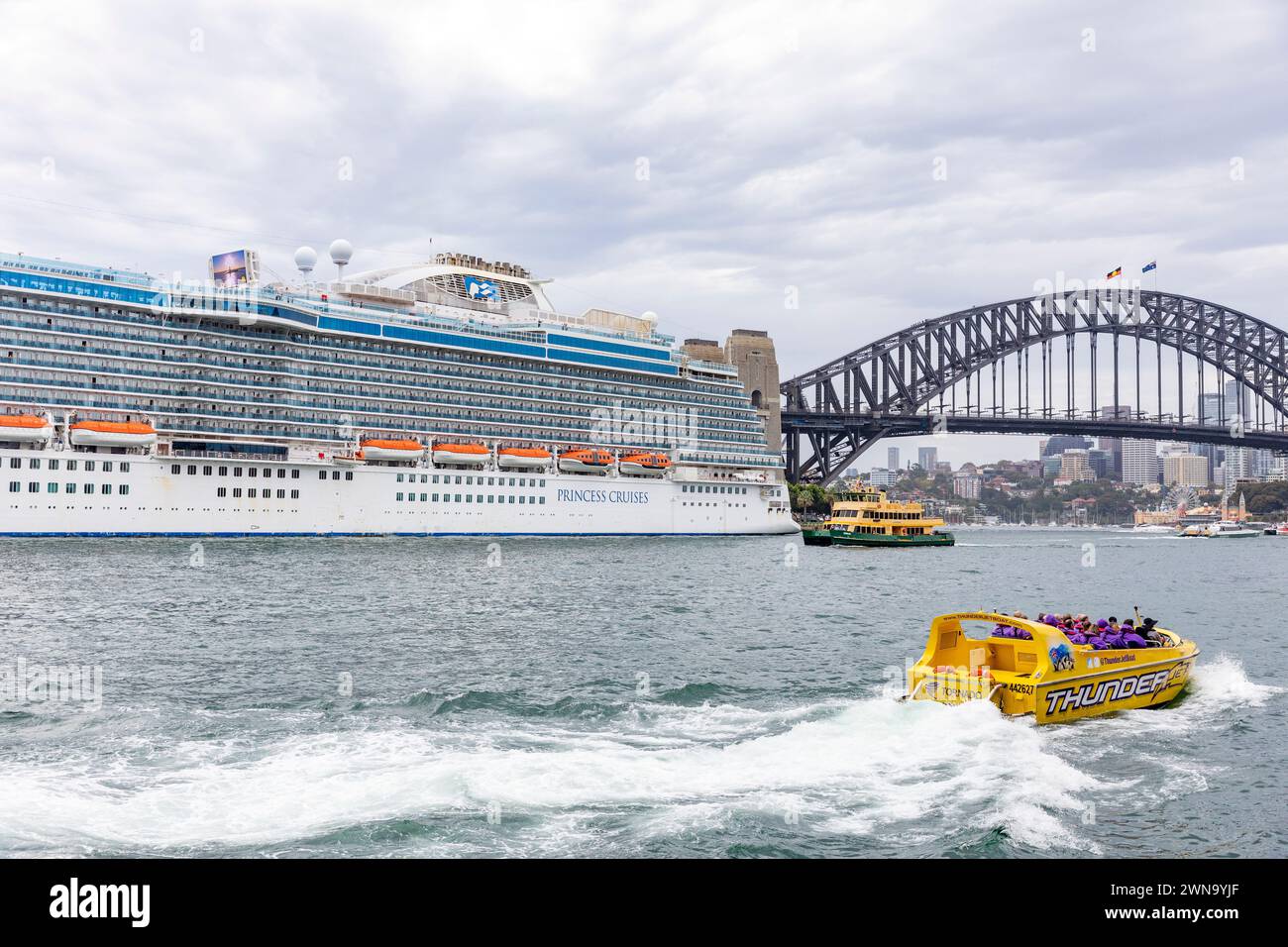 Sydney Australien, die Kunden beginnen eine Fahrt mit dem Jetboot um den Hafen von Sydney, vorbei an dem Kreuzfahrtschiff Majestic Princess, das im Circular Quay 2024 vor Anker liegt Stockfoto