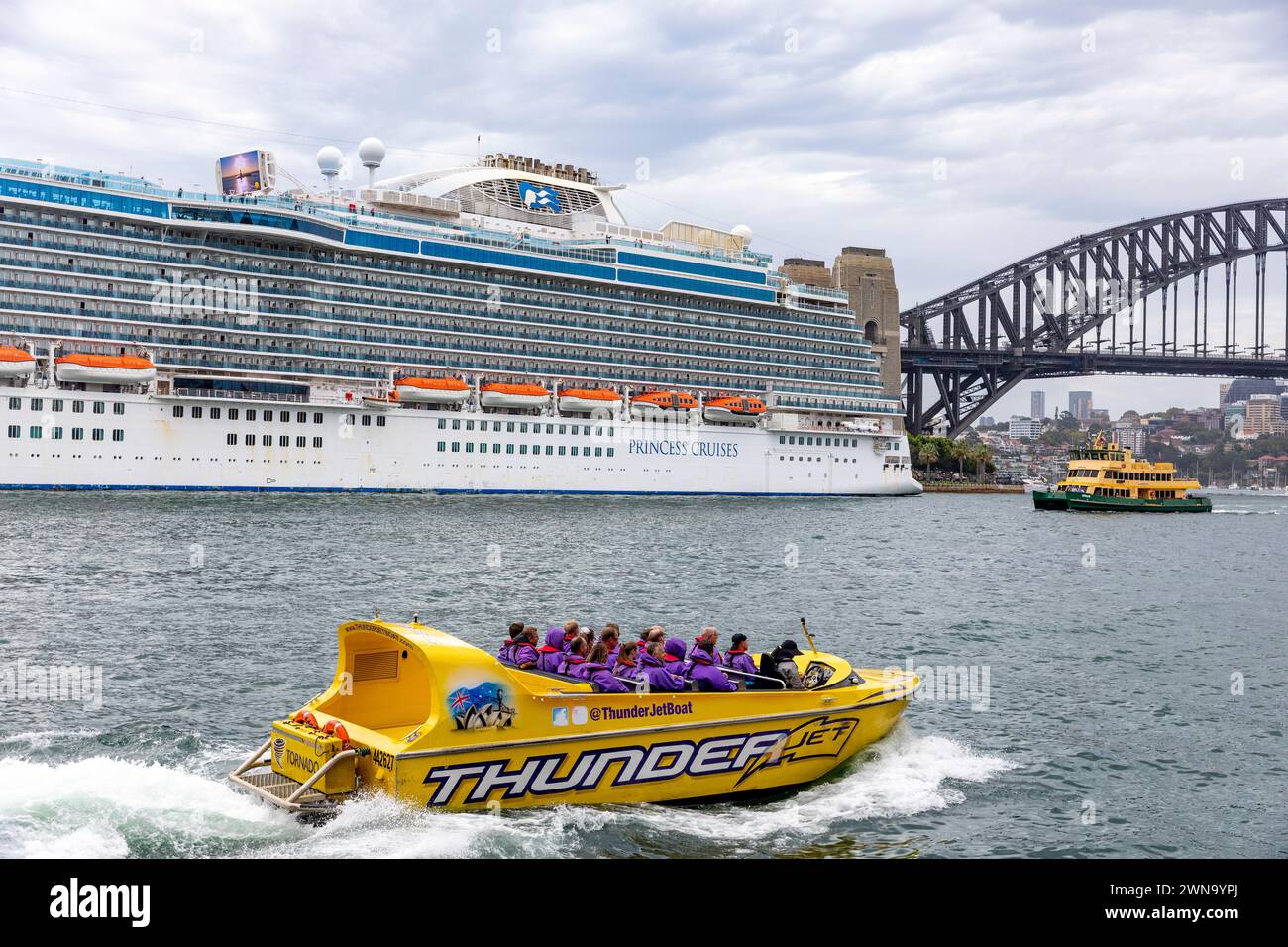 Sydney Australien, die Kunden beginnen eine Fahrt mit dem Jetboot um den Hafen von Sydney, vorbei an dem Kreuzfahrtschiff Majestic Princess, das im Circular Quay 2024 vor Anker liegt Stockfoto