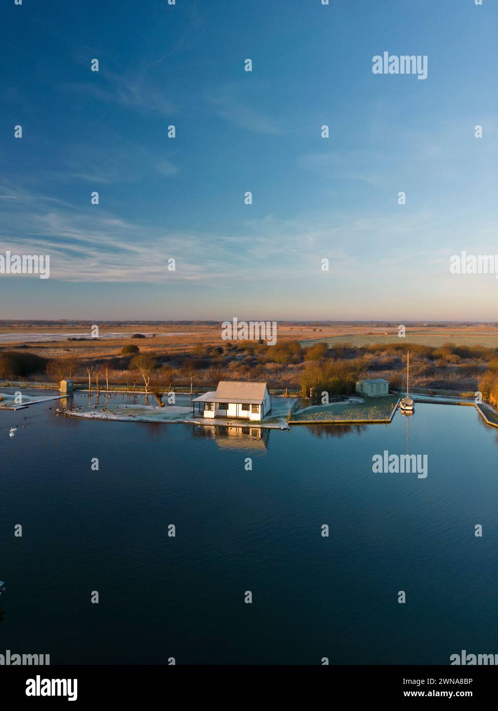 Blick am frühen Morgen über den ruhigen Fluss Thurne auf den Norfolk Broads und ein eingeschlossener Urlaubsort in der Nähe des Dorfes Thurne. Stockfoto