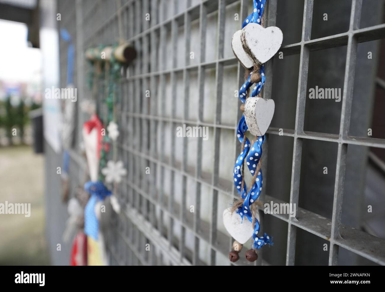 Hamburg, Deutschland. März 2024. Hölzerne Herzen hängen vor dem Eingang zum Königssaal der Zeugen Jehovas im Stadtteil Alsterdorf. Am 9. März 2024 jährt sich der Mordanschlag eines ehemaligen Gemeindemitglieds. Der 35-jährige Philipp F. erschoss sieben Menschen - darunter ein ungeborenes Kind - und sich selbst. Nach Angaben eines Sprechers der Zeugen Jehovas nutzt die Gemeinde das Gebäude nicht mehr für Treffen. Quelle: Marcus Brandt/dpa/Alamy Live News Stockfoto