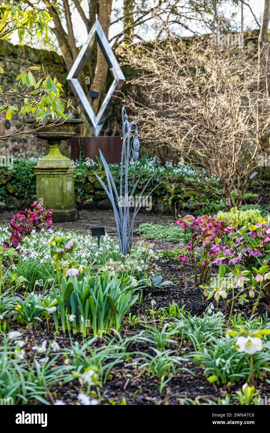 Dekorative Metallskulpturen und Schneeglöckchen im Frühling, Shepherd House Garden, Inveresk, East Lothian, Schottland, UK Stockfoto