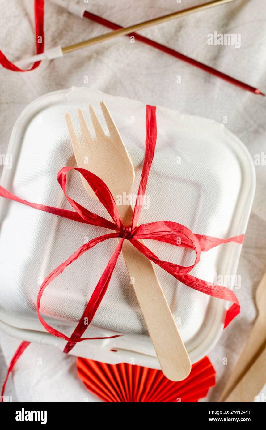 Weiße bento-Kuchenbox mit roter Schleife. Geschenkbox mit leckerem bento. Kuchenverpackung. Lieferung. Stockfoto