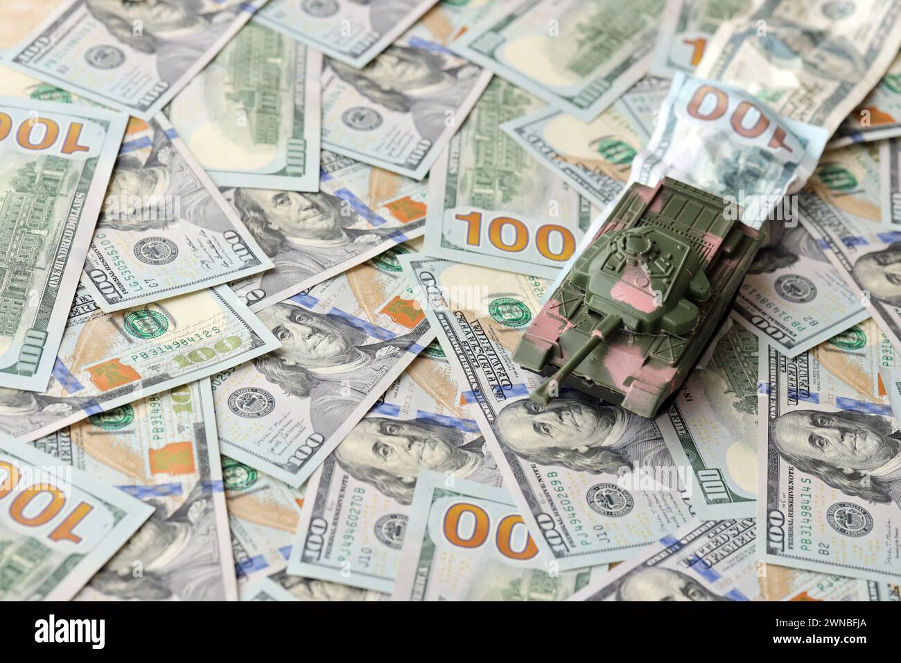 Tank auf zerknitterten 100-Dollar-Banknoten. Hintergrund der Kriegsfinanzierung und des militärischen Unterstützungspreises für die Vereinigten Staaten von Amerika Stockfoto