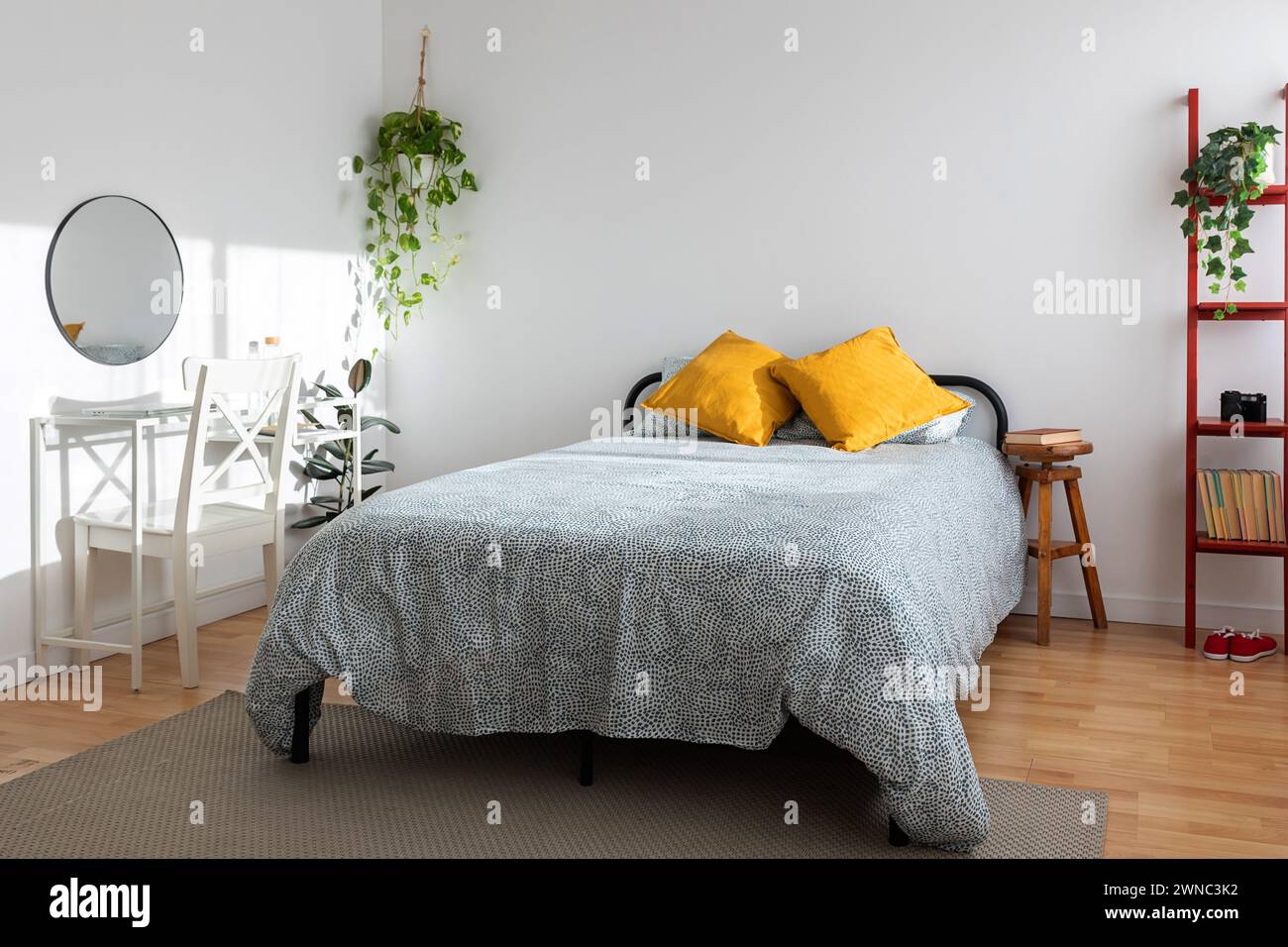 Helles, minimalistisches, gemütliches Schlafzimmer mit Bett und Tisch Stockfoto