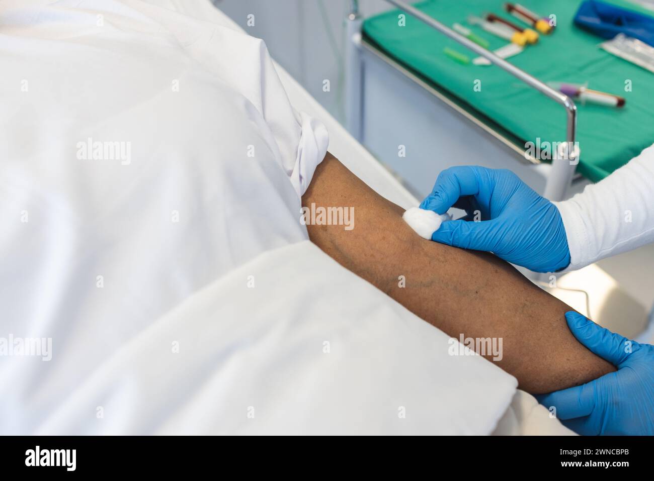 Ein medizinisches Fachpersonal bereitet den Arm eines Patienten auf ein Verfahren vor Stockfoto