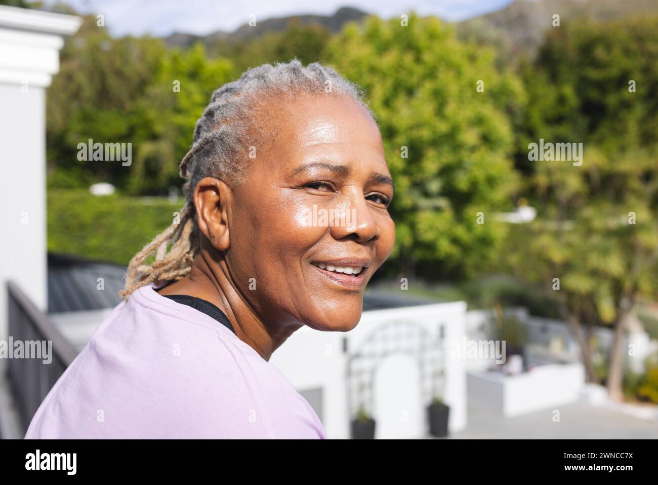 Ältere Frau mit grauen Haaren genießt die Sonne im Freien Stockfoto