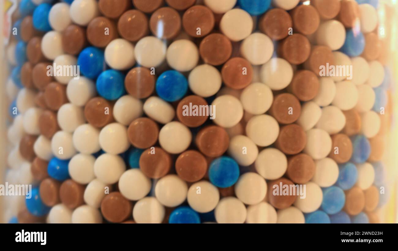 Ein Nahaufnahme-Unschärfefoto eines Gefäßes mit bunten Süßigkeiten, die wie Medikamente aus der Geschichte aussehen Stockfoto