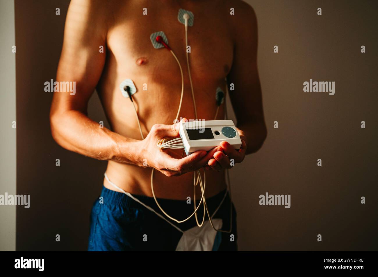Heart Health Check: Junger Mann wird EKG-Monitoring-Sitzung unterzogen und stellt präzise Messwerte für ein ganzheitliches Verständnis seiner kardiovaskulären Fitness vor Stockfoto
