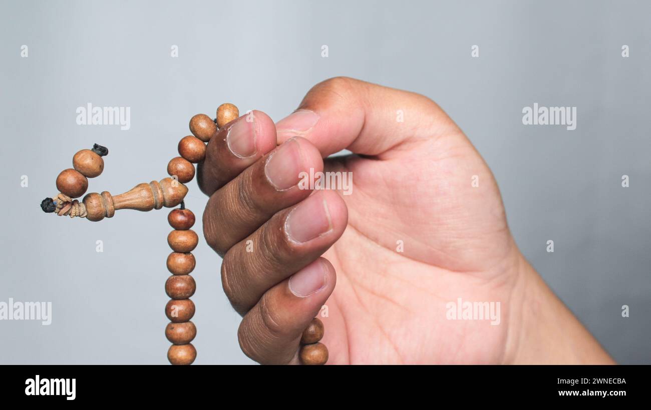 Hände, die Rosenkranzperlen halten. Ramadan Kareem Hintergrund. Stockfoto