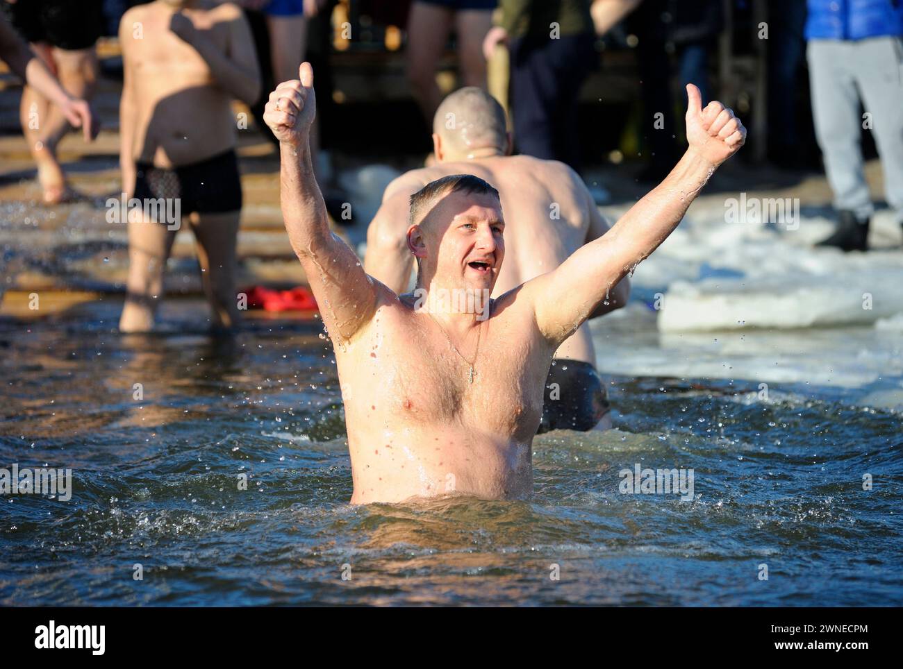 Der Mann zeigt mit den Daumen nach oben, dass er sich gut fühlt, nachdem er in eiskaltes Wasser getaucht ist. Das fest Epiphany am Fluss Dnipro. Kiew, Ukraine. Januar 2019 Stockfoto