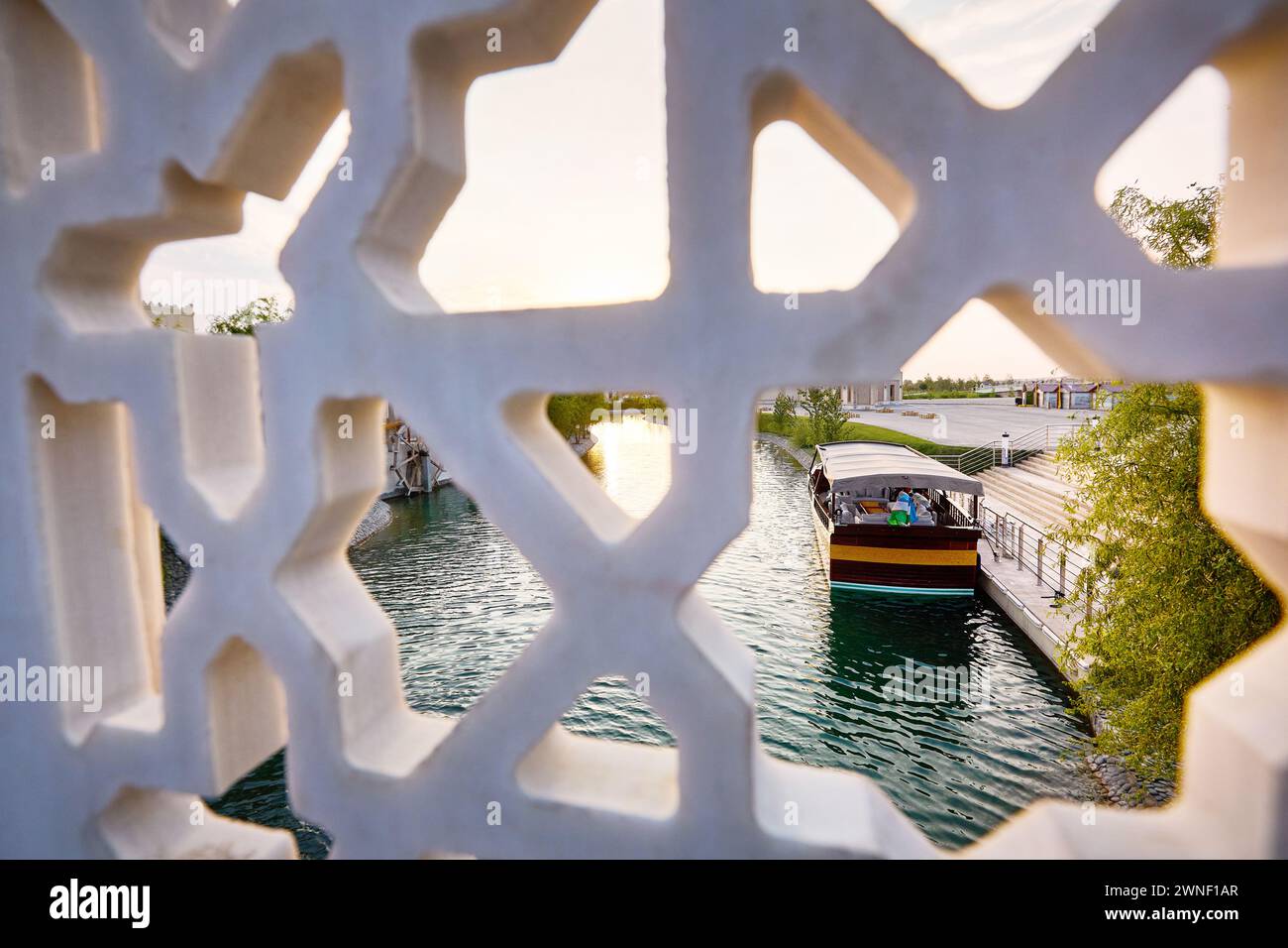 Boot auf dem Pier am Wasserkanal Samarkand Eternal City Boqiy Shahar Registan Complex und Marmorbrücke mit Sternmuster im Vordergrund. Stockfoto