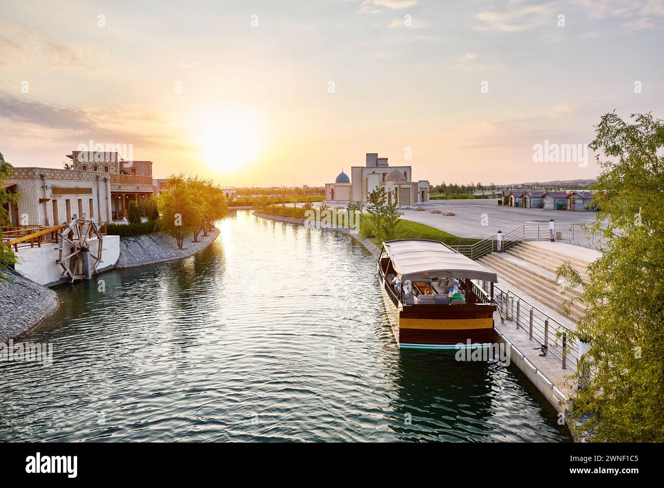 Boot auf dem Pier am Wasserkanal Samarkand Eternal City Boqiy Shahar Registan Complex bei Sonnenuntergang. Stockfoto