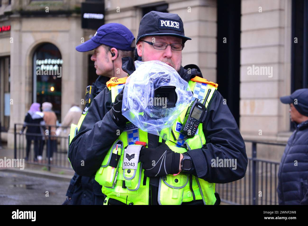 Polizeibeamte filmen eine pro-palästinensische Proteste, im Zentrum von Manchester, Großbritannien, 2. März 2024 Stockfoto