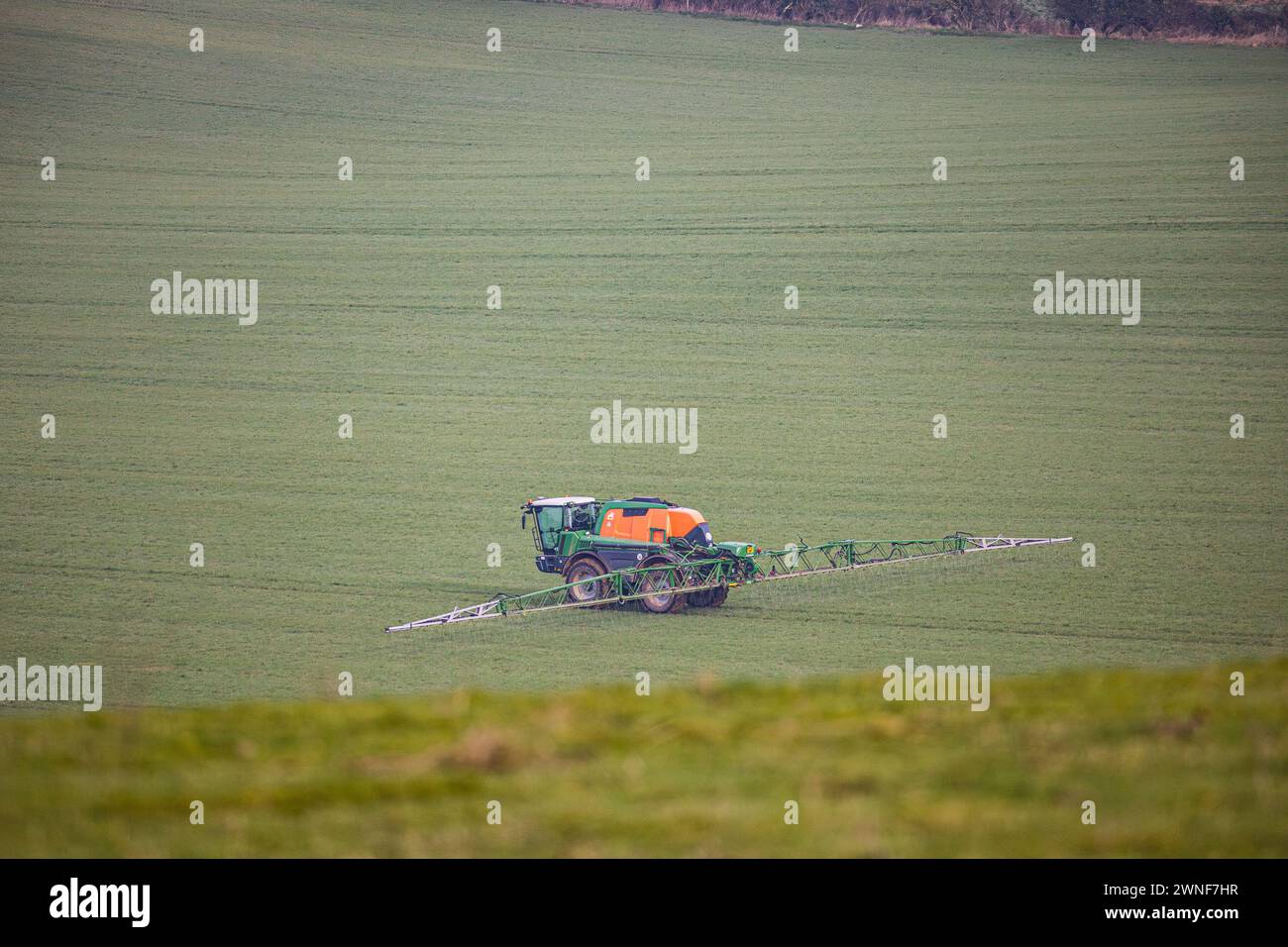 Spritzen von Traktorfrüchten in einer Feldlandschaft in wiltshire, britische Landwirtschaft Stockfoto