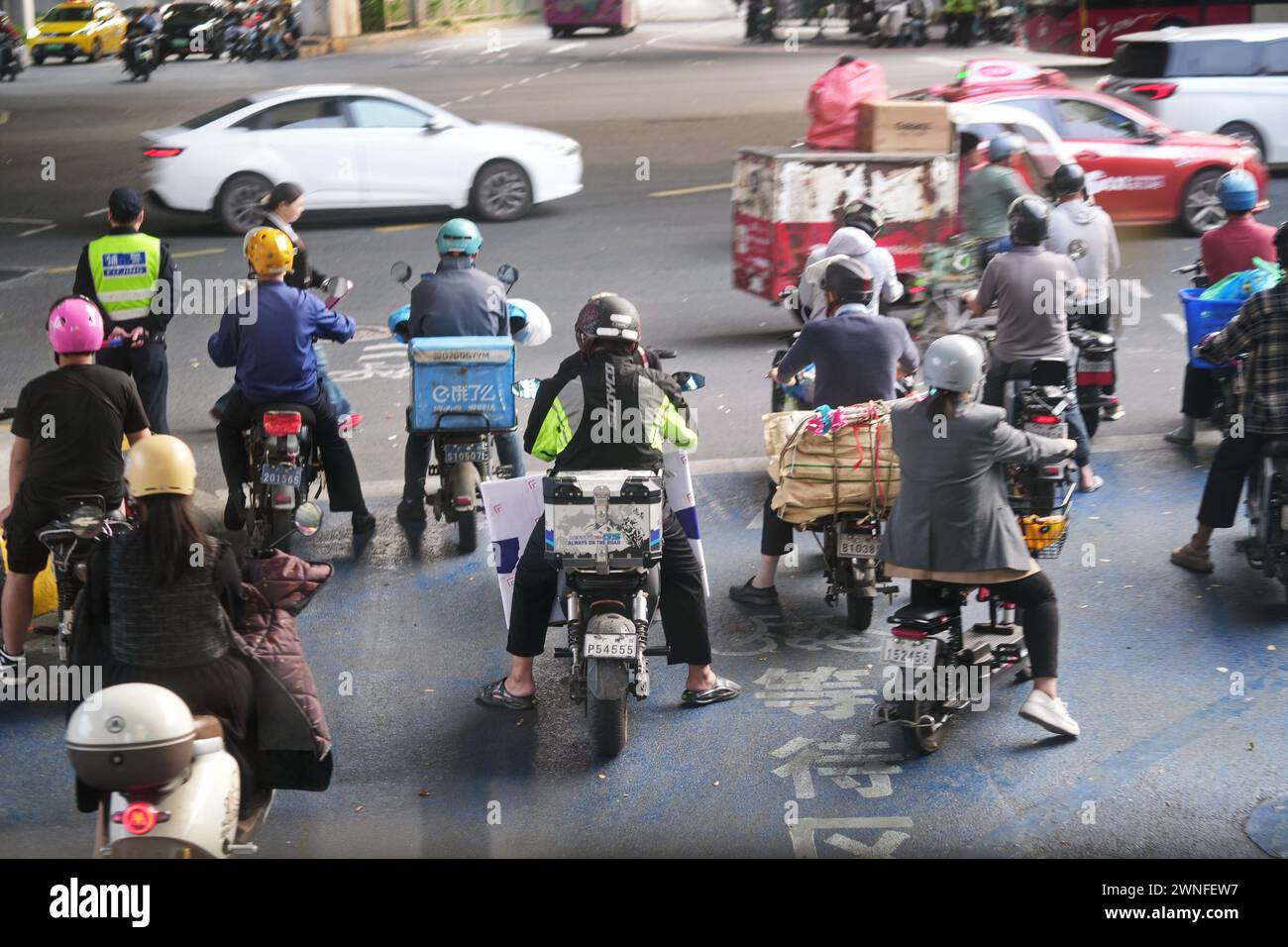 GUANGZHOU, CHINA - 22. Februar 2024: Menschen auf ELEKTROROLLERN auf der Straße Stockfoto