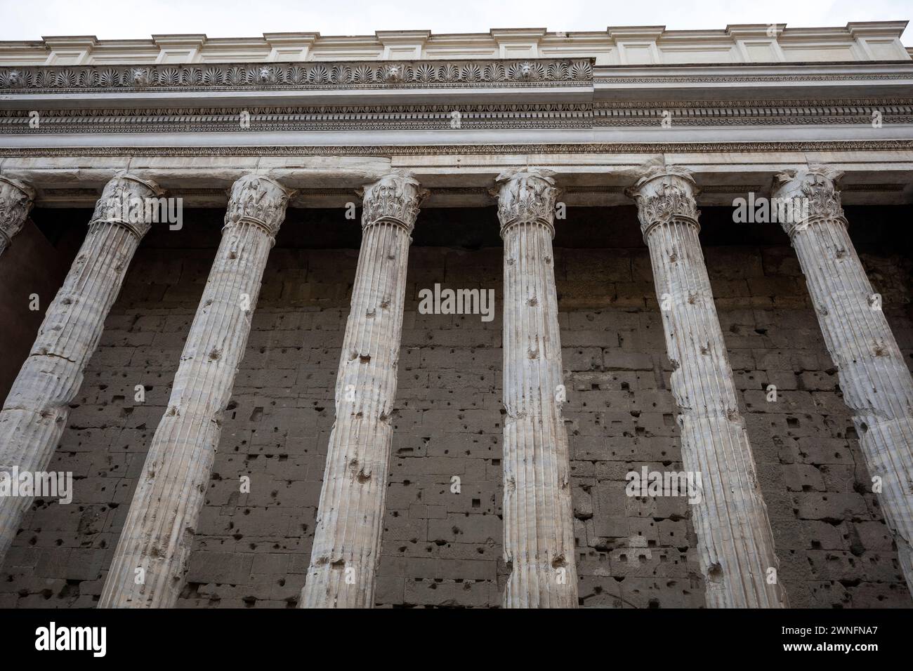 Die antike Fassade des Tempio di Adriano (Adrianentempel) im historischen Zentrum von Rom, Italien. Perspektive der antiken Kolonnade im Foregr Stockfoto