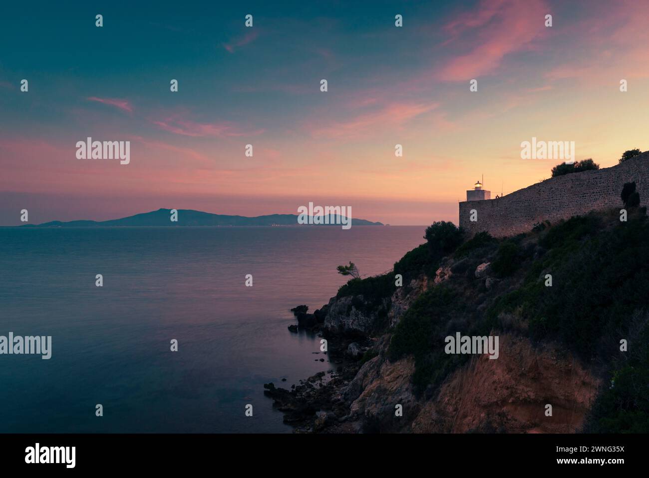Talamone Leuchtturm vor dem Meer und Monte Argentario in der Dämmerung, Toskana, Italien Stockfoto