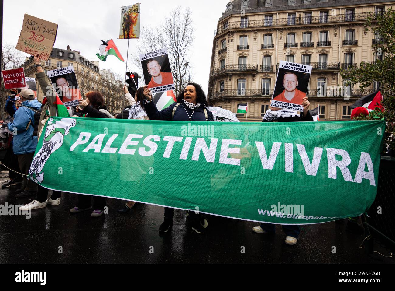 Demonstranten sahen Fotos von Aaron Bushnell und ein Banner mit der Aufschrift „Palästina wird leben“ während des Protestes. Dutzende von Menschen versammelten sich am Place St. Augustin in Paris, um Aaron Bushnell zu ehren, dem jungen amerikanischen Soldaten, der sich vor der israelischen Botschaft in Washington opferte, aus Protest gegen den Völkermord im Gazastreifen. Stockfoto