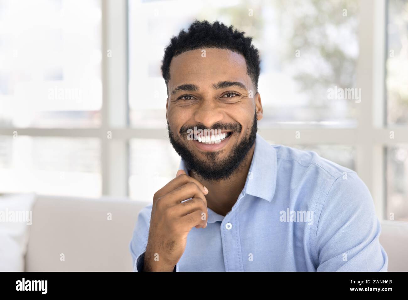 Glücklicher, gutaussehender junger Afrikaner, der in die Kamera schaut Stockfoto