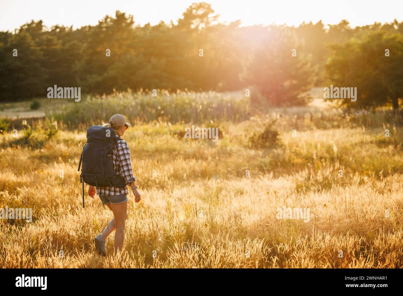 Alleinwanderer auf der Reise. Wandern und Abenteuer im Sommer. Frau mit Rucksack wandert allein auf einer langen Reise in die Natur Stockfoto