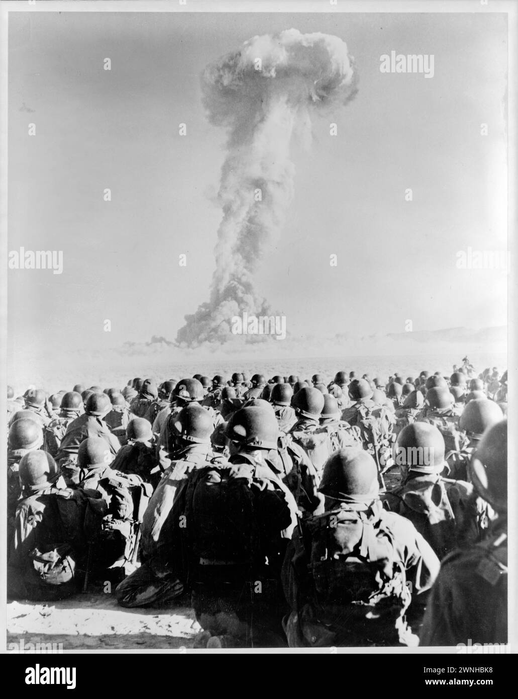 November 1951. Nevada - Frenchman's Flat - Mitglieder von 11th ab Div Knie auf dem Boden, während sie die Pilzwolke des Atombombentests beobachten Stockfoto