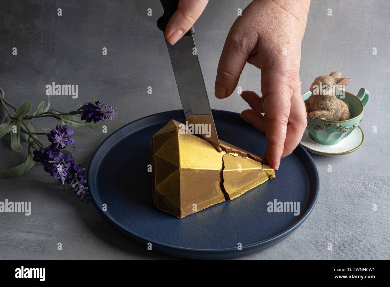 Low Key Belgische Milchschokolade Osterei in goldener Vorderform 8. Stockfoto