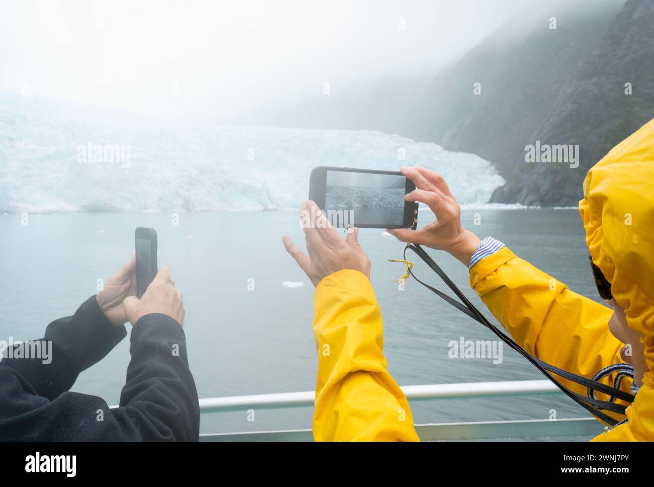 Touristen machen Fotos vom Holgate-Gletscher mit Smartphones im Regen. Kenai Fjords National Park. Seward. Alaska. Stockfoto