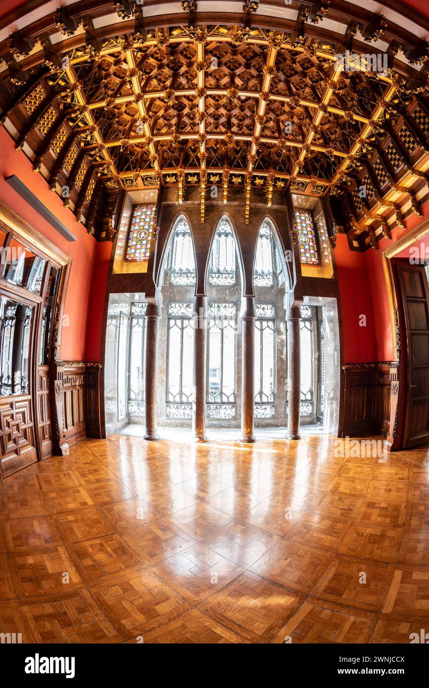 Besuchsraum des Palau Güell Palastes mit einer spektakulären Holzdecke und Fenstern mit Parabelbögen und Säulen (Barcelona, Katalonien, Spanien) Stockfoto