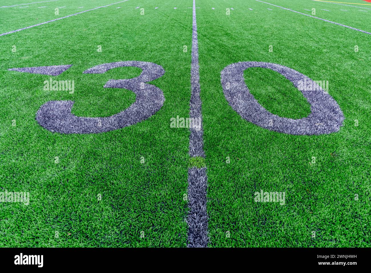 Kunstrasen Fußball 30 Yard Line und Block Style Zahlen in Grau. Die Markierungen für den Trainingsfußball sind weniger offensichtlich und werden im Außenfeld angebracht Stockfoto