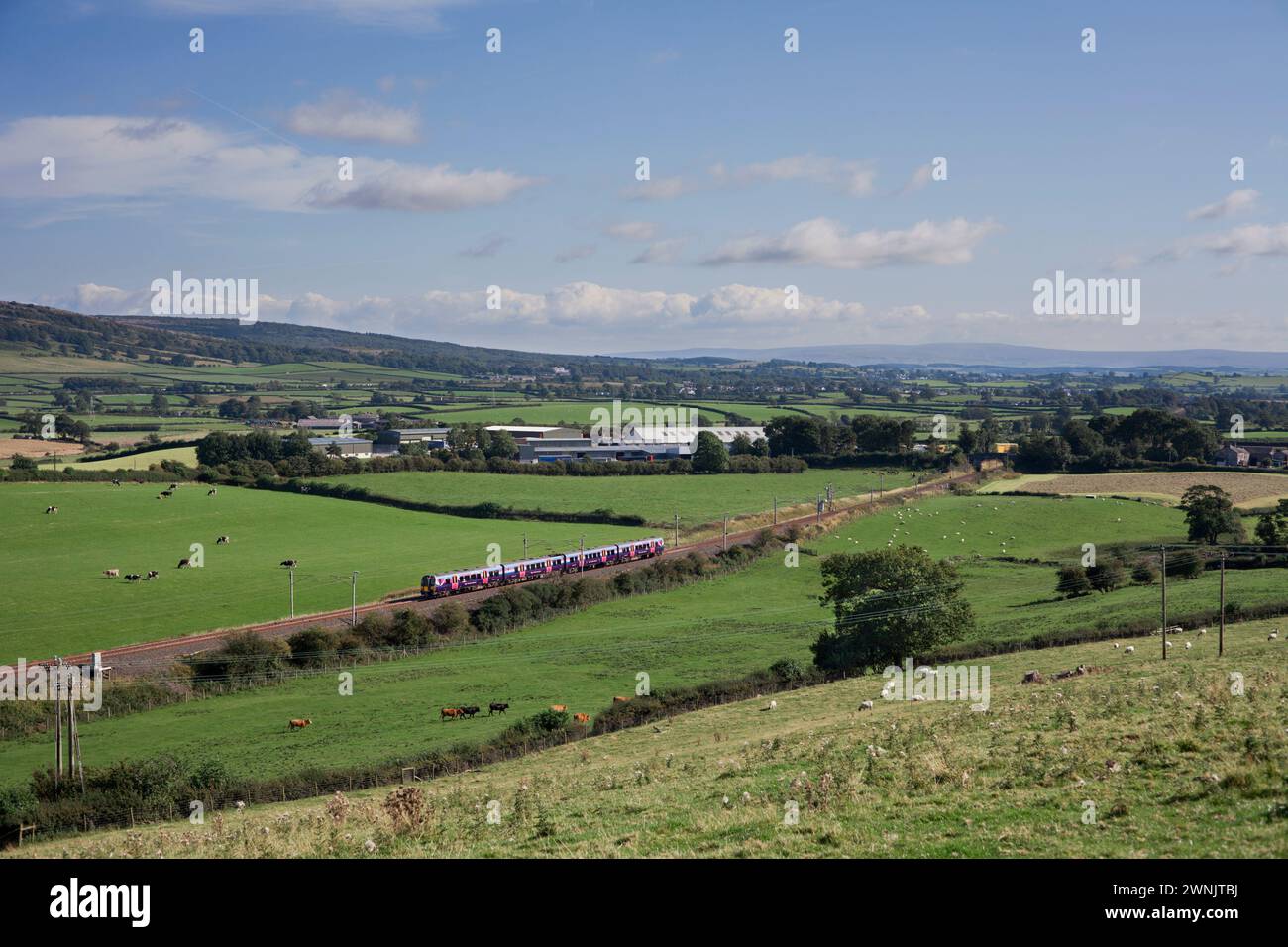 Erster elektrischer Zug der Baureihe 350 des TransPennine Express auf der Hauptstrecke der Westküste in Cumbria mit einem Zug vom Flughafen Manchester nach Edinburgh Stockfoto