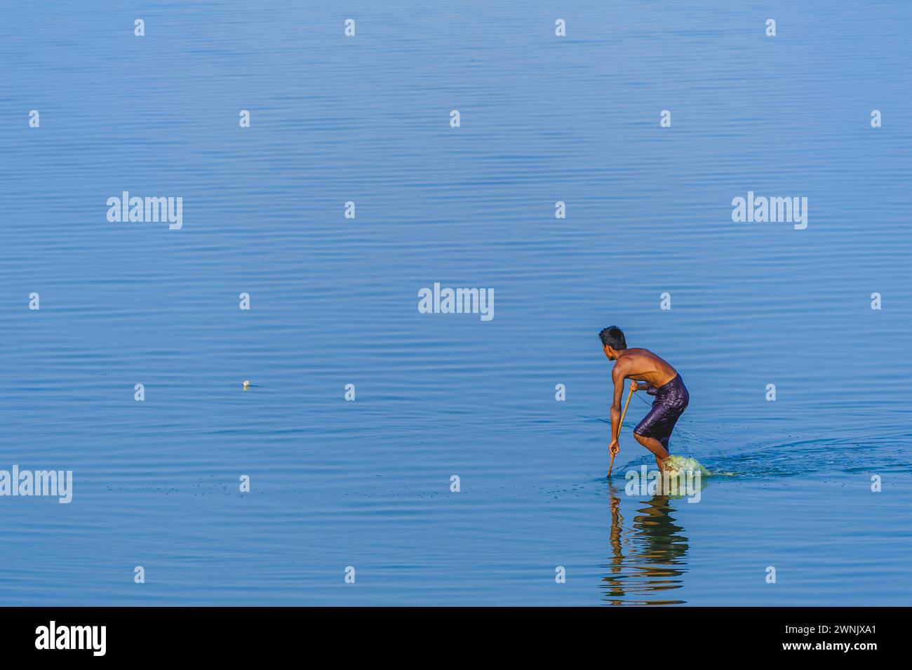 13. Februar 2016: Fischer ziehen es vor, tief im matschigen Wasser zu waten, um im Taungthaman Lake nahe Amarapura in Myanmar nach Fischen zu suchen. Stockfoto